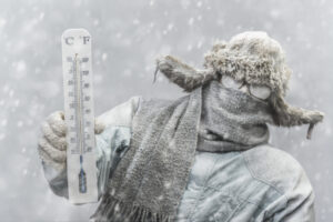 Frozen man holding a thermometer while it is snowing