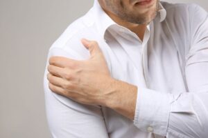 Young,Man,Suffering,From,Pain,In,Shoulder,,Closeup